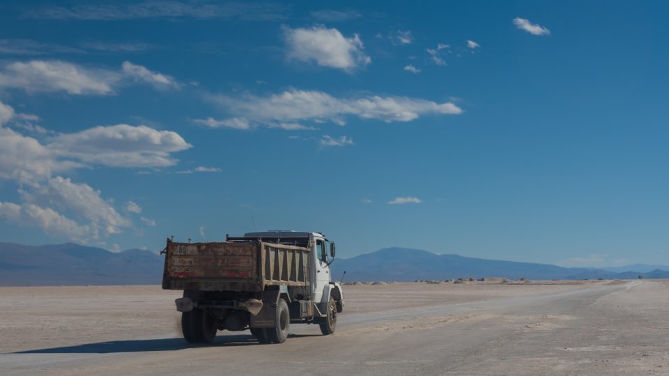 a dump truck driving down a desert road